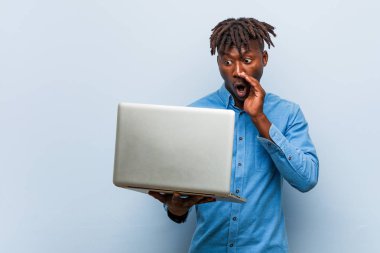 Genç rasta siyah adam ön heyecanlı bağırarak bir dizüstü bilgisayar tutan.