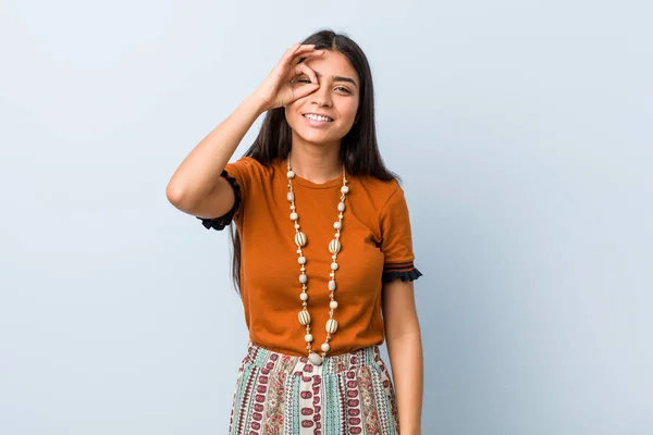 Young arab woman excited keeping ok gesture on eye.