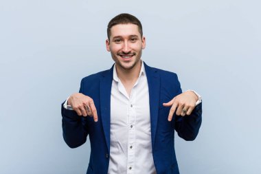 Genç beyaz iş adamı parmaklarıyla aşağı bakıyor, olumlu hisler..