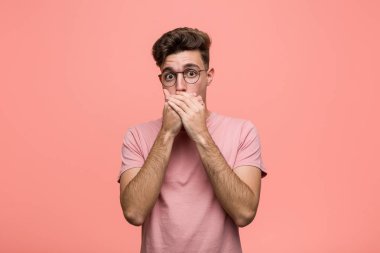 Genç serin beyaz adam elleriyle ağız kapsayan şok.