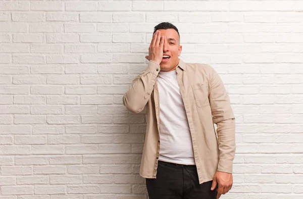 Jovem Latino Gritando Feliz Cobrindo Rosto Com Mão — Fotografia de Stock