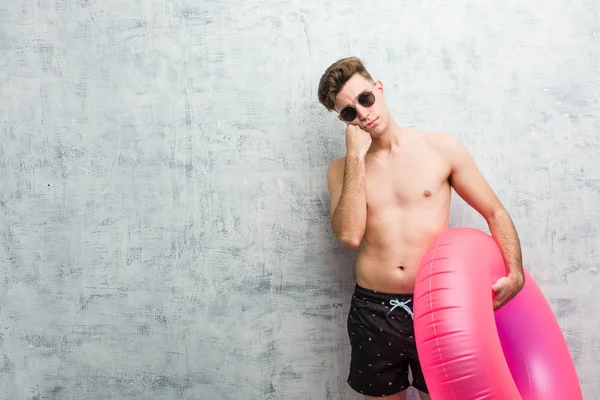 Młody Mężczyzna Trzyma Różowy Nadmuchiwany Pączek Ubrany Strój Kąpielowy Który — Zdjęcie stockowe