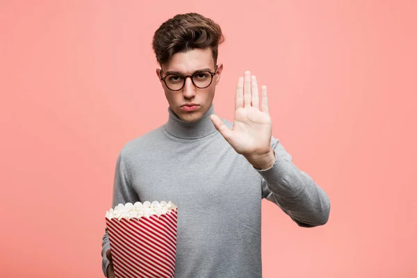 Young Intellectual Man Holding Popcorn Bucket Pointing His Temple Finger — Stock Photo, Image