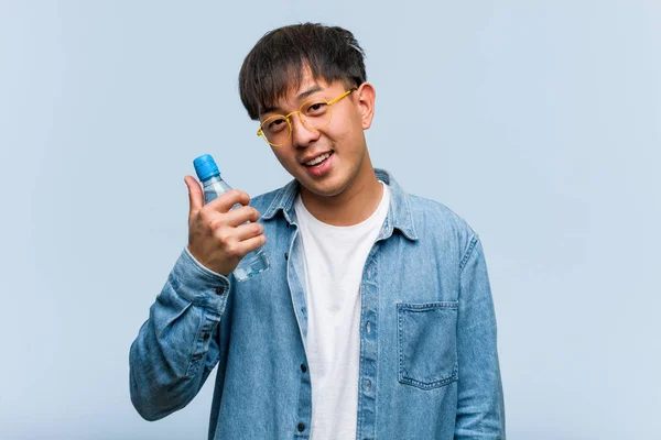 Joven Chino Sosteniendo Una Botella Agua Sonriendo Levantando Pulgar Hacia — Foto de Stock