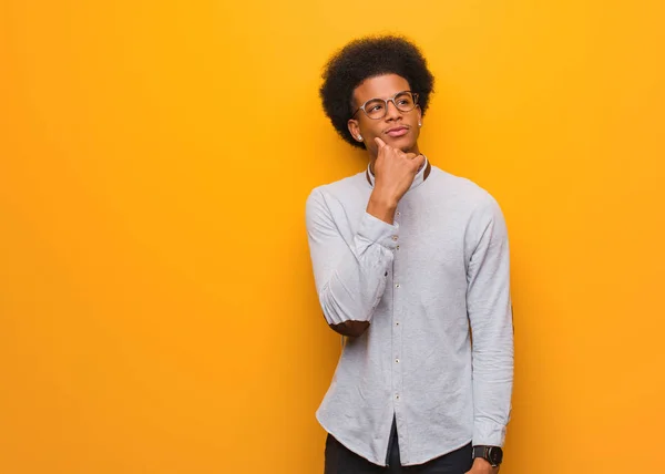 Jovem Afro Americano Sobre Uma Parede Laranja Duvidosa Confusa — Fotografia de Stock