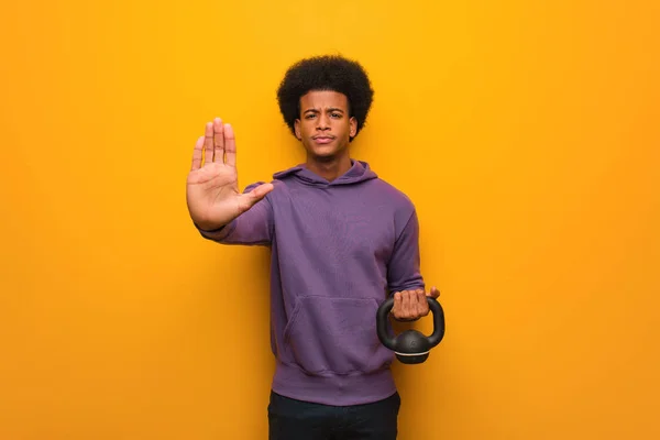 ダンベルを前に手をつないでいる若いアフリカ系アメリカ人フィットネスマン — ストック写真