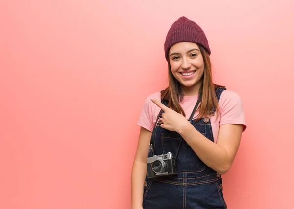 若いかわいい写真家の女性が微笑み 横を指差す — ストック写真