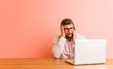 Bir çağrı merkezinde çalışan genç adam sızlanıyor ve ayrıayrı ağlıyor.