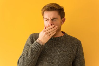 Genç Redhead adam yüz kapatmak yorgun ve çok uykulu