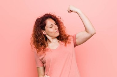 Genç doğal ve otantik kızıl saçlı kadın bir zafer, kazanan kavramı sonra yumruk yükselterek.