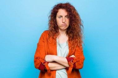 Genç kızıl saçlı zarif kadın alaycı ifade ile kamera bakarak mutsuz.