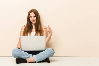 Genç zencefil kadın bir gömlek kopyalama alanı, gurur ve kendinden emin elle işaret evinin zemin kişi oturuyor