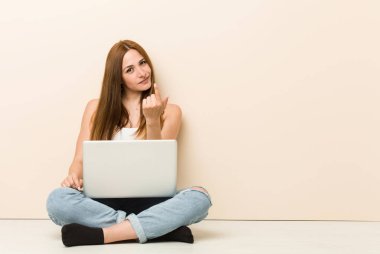 Genç zencefilkadın evinin zemininde otururken seni parmakla işaret ediyor sanki davet ediyormuş gibi yaklaşın.