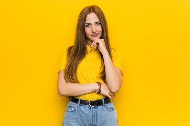 Genç zencefil kızıl saçlı kadın mutlu ve kendinden emin gülümseyen, el ile çene dokunmadan.