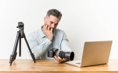 Genç yakışıklı fotoğrafçılık öğretmeni tırnakısırma, sinir ve çok endişeli.