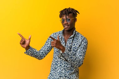 Genç siyah rasta adam bir fotokopi alanı için işaret parmakları ile işaret eden bir tatil bakmak giyen, heyecan ve arzu ifade.