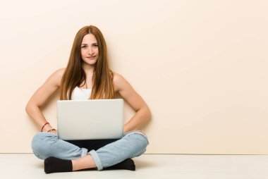 Genç zencefil kadın kalça ellerini tutarak emin evinin katta oturan.