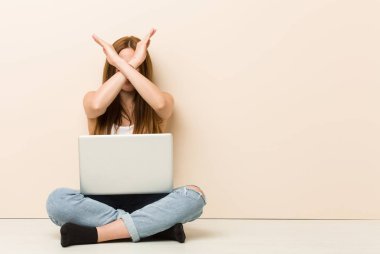 Genç zencefil kadın iki kol çapraz tutarak evinin zemininde oturan, inkar kavramı.