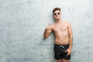 Genç beyaz adam mayo giyen kişi bir gömlek kopyalama alanı, gururlu ve kendinden emin elle işaret