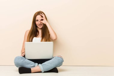 Genç zencefil kadın evin in katta oturan göz ok jest tutarak heyecanlı.