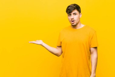 Genç İspanyol rahat adam avuç içi üzerinde kopya alanı tutarak etkilendim.