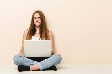 Genç zencefil kadın evinin katta şaşkın oturan, şüpheli ve emin hissediyor.