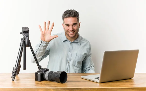 Young handsome photography teacher smiling cheerful showing number five with fingers.