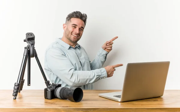 Young handsome photography teacher excited pointing with forefingers away.