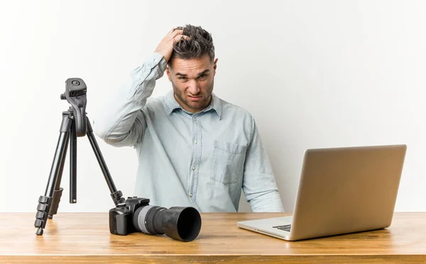 Young handsome photography teacher tired and very sleepy keeping hand on head.