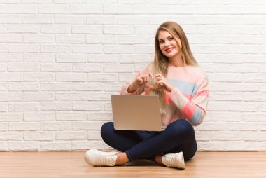 Genç Rus öğrenci kadın elleri ile bir kalp şekli yapıyor oturuyor