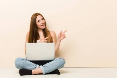 Genç zencefil kadın evinin zemininde oturan heyecanlı ön parmakları ile işaret.