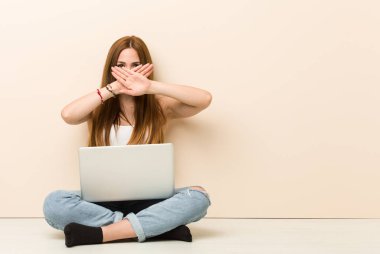 Genç zencefilkadın evinin zemininde bir inkar jesti yapıyor oturuyor