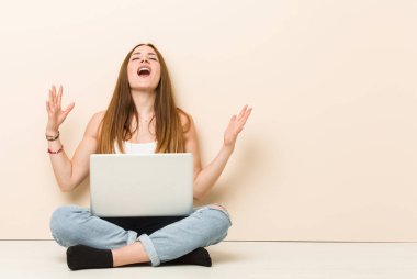 Genç zencefilkadın evinin zemininde gökyüzüne çığlık, yukarı bakarak, sinirli otururken.