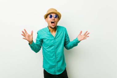 Bir zafer ya da başarı kutlayan bir yazlık giysiler giyen genç İspanyol adam, o şaşırır ve şok.