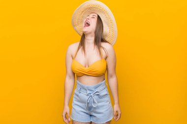 Hasır şapka takan genç beyaz kadın, yaz görünümünde rahat ve mutlu gülerek, boynu gerilmiş dişleri.