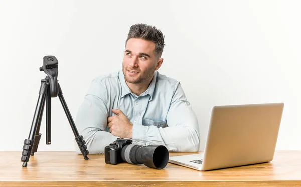 Young handsome photography teacher smiling confident with crossed arms.