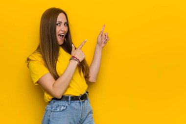 Genç kızıl kızıl saçlı kadın bir kopyasını alana işaret, heyecan ve arzu ifade.