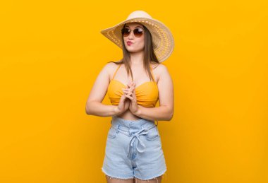 Hasır şapka takan genç beyaz kadın, yaz görünümü nde plan yapmayı, bir fikir kurmayı.