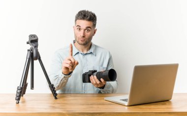 Genç yakışıklı fotoğraf öğretmeni parmak ile bir numara gösteren.