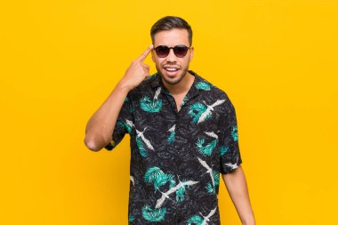 Genç filipinli adam işaret parmağı ile bir hayal kırıklığı jest gösteren yazlık giysiler giyiyor.