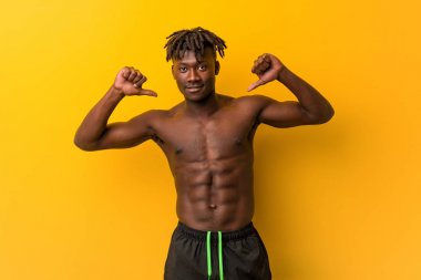 Genç siyah adam gömleksiz mayo giyen gurur ve kendinden emin hissediyor, örnek takip etmek.