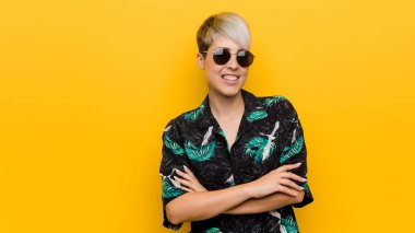 Genç kıvrımlı kadın bir yaz görünüm çapraz kolları ile kendinden emin gülümseyen giyiyor.