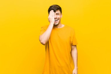 Genç İspanyol rahat adam palmiye ile yüz yarısını kapsayan eğlenmek.