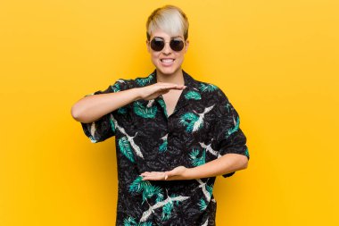 Genç kıvrımlı kadın bir yaz bakmak iki eliyle bir şey tutarak giyiyor, ürün sunumu.