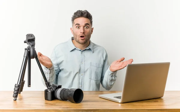 Young handsome photography teacher surprised and shocked.