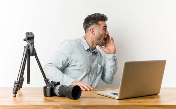 Young handsome photography teacher shouting and holding palm near opened mouth.