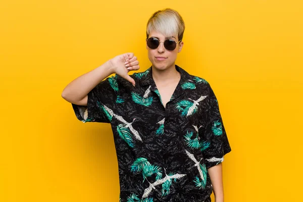 Genç kıvrımlı kadın bir yaz bir görünüm giyen bir sevmediğim jest gösteren, başparmak aşağı. Anlaşmazlık kavramı.