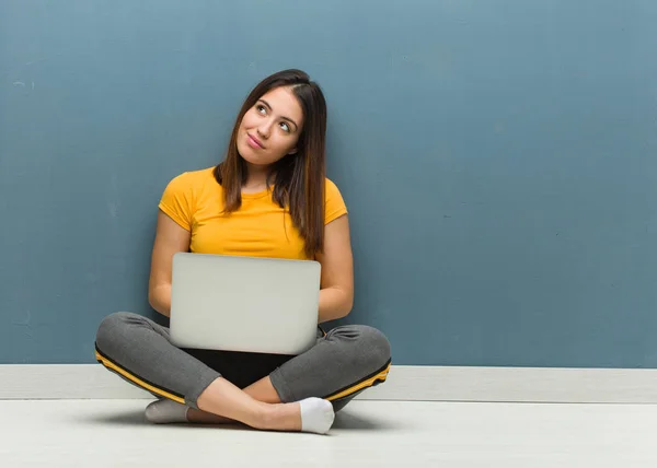 Νεαρή Γυναίκα Κάθεται Στο Πάτωμα Ένα Φορητό Υπολογιστή Ονειρεύεται Την — Φωτογραφία Αρχείου