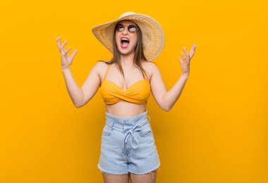 Hasır şapka takan genç beyaz kadın, yaz gözü öfkeyle çığlık atıyor.