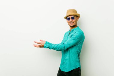 Bir avuç üzerinde bir kopya alanı tutan bir yazlık giysiler giyen genç İspanyol adam.